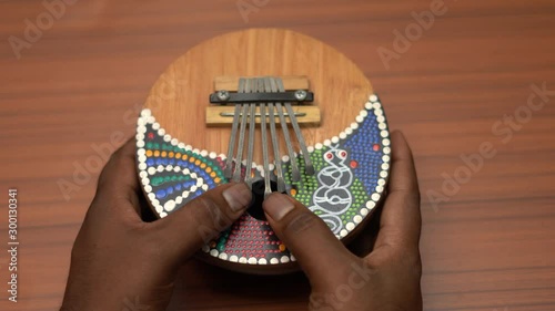 Playing Kalimba instrument . Kalibma is also knows as hand piano photo