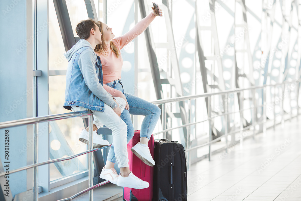Fototapeta premium Couple traveling. Lovers journey. Young man and woman in the airport. Family tour.