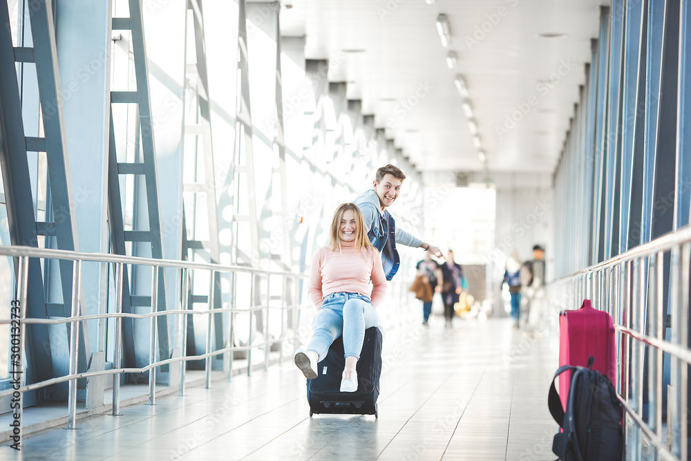 Fototapeta premium Couple traveling. Lovers journey. Young man and woman in the airport. Family tour.