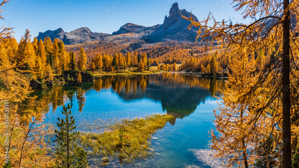 Golden reflections on the Federa lake. Dreamlike Dolomites. Italy