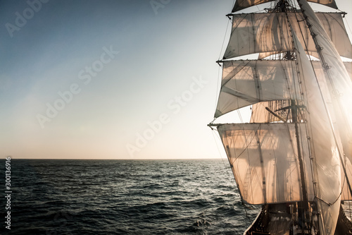Backlit sails of a traditional tall ship on the atlantic