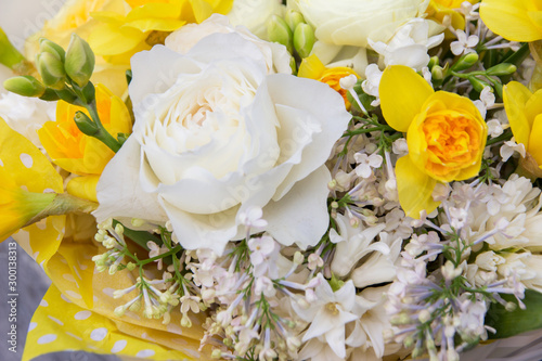 Floral  flowers background. White rose  lilac and yellow narcissus close-up in bouquet 