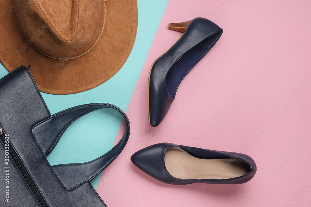 Felt hat, high heel shoes, leather bag on pink blue pastel background. Minimalistic fashion concept. Top view Felt hat, high heel shoes, leather bag on pink blue pastel background. Minimalistic fashion concept. Top view