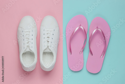 Sneakers and flip-flops on colored paper background. Minimalistic fashion concept. Top view