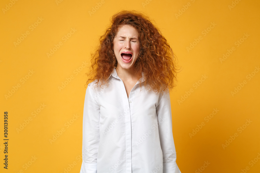 Frustrated young redhead woman girl in white shirt posing isolated on yellow orange wall background, studio portrait. People lifestyle concept. Mock up copy space. Keeping eyes closed, screaming. Frustrated young redhead woman girl in white shirt posing isolated on yellow orange wall background, studio portrait. People lifestyle concept. Mock up copy space. Keeping eyes closed, screaming.