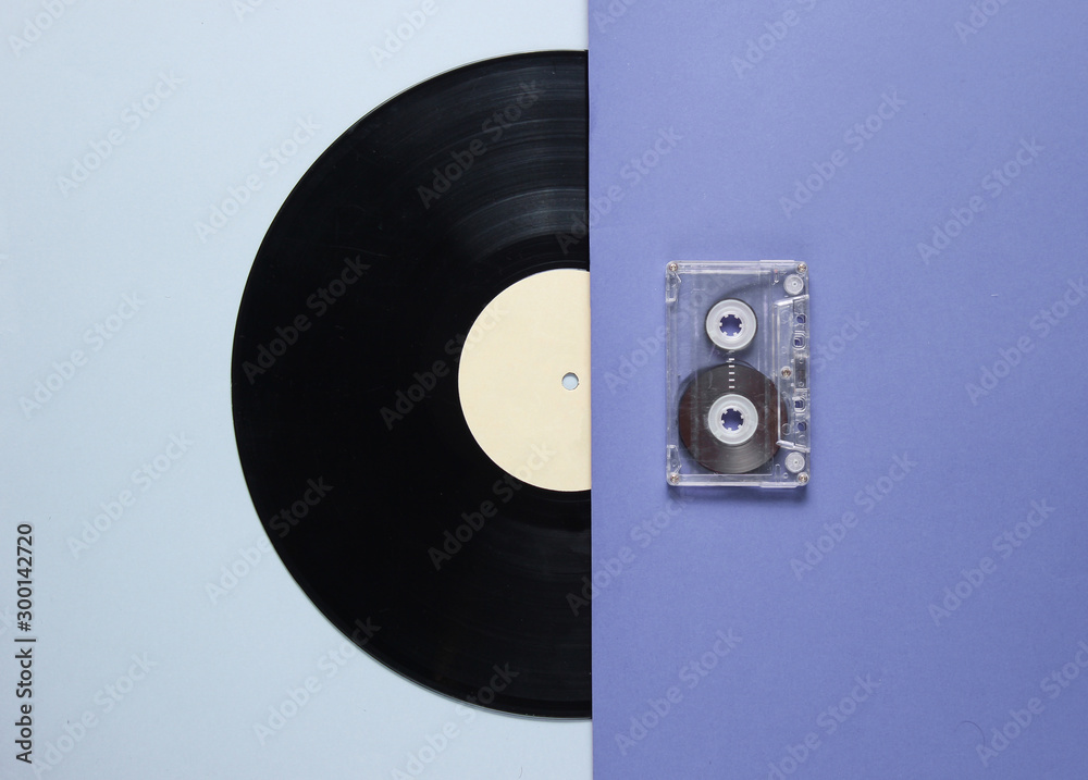 Obraz premium Audio cassette, vinyl record on blue gray background. Retro style. Top view