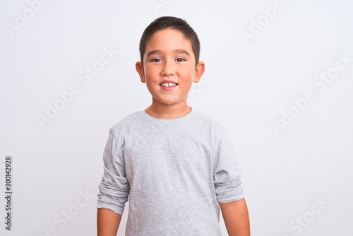 Beautiful kid boy wearing grey casual t-shirt standing over isolated white background with a happy and cool smile on face. Lucky person.
