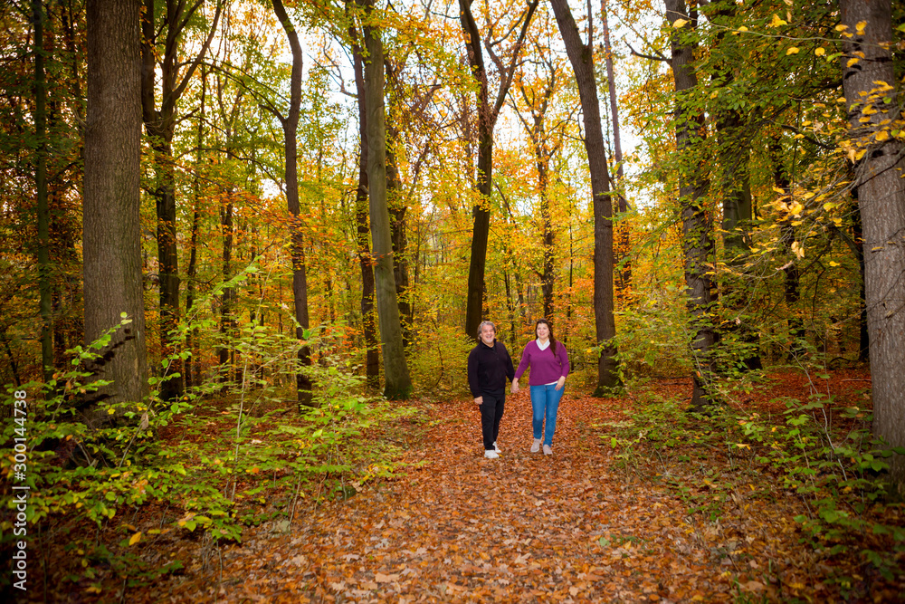Couple walking in the forest during a late autumn afternoon. Couple walking in the forest during a late autumn afternoon.