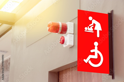 mother's room and disabled toilet sign on red tab with red siren light hang above the door of public toilet photo