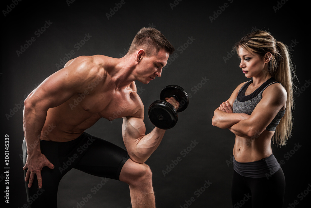 Plakat Sporty young couple posing on black background