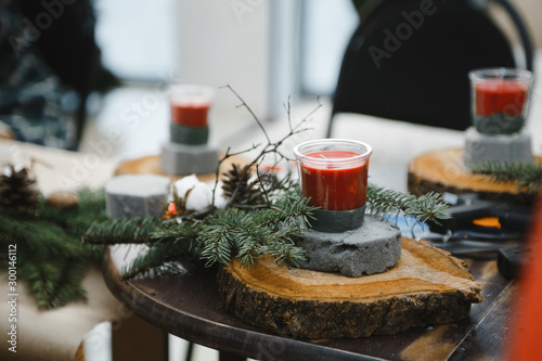 making Christmas decorations from red candles  Christmas tree branches and cones