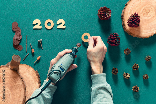 Fotografija On the table there is a production of wooden figures for the celebration of the new year and Christmas using an electric engraver and a special tool