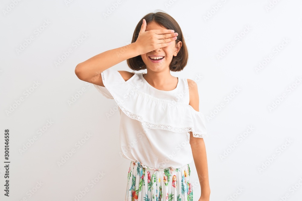 Young beautiful child girl wearing casual dress standing over isolated white background smiling and laughing with hand on face covering eyes for surprise. Blind concept. Young beautiful child girl wearing casual dress standing over isolated white background smiling and laughing with hand on face covering eyes for surprise. Blind concept.