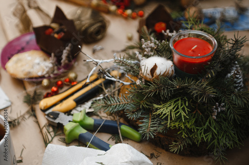 making Christmas decorations from red candles, Christmas tree branches and cones