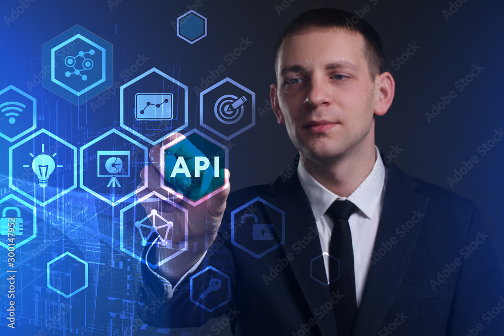 Business, Technology, Internet and network concept. Young businessman working on a virtual screen of the future and sees the inscription: API Business, Technology, Internet and network concept. Young businessman working on a virtual screen of the future and sees the inscription: API