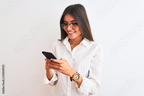 Beautiful businesswoman wearing glasses using smartphone over isolated white background with a happy face standing and smiling with a confident smile showing teeth