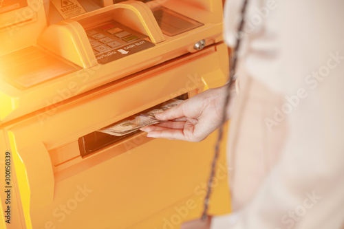 hand taking dollar bills out of an ATM