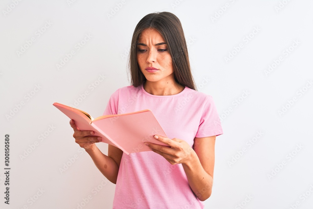 Young beautiful student woman reading book standing over isolated white background with a confident expression on smart face thinking serious Young beautiful student woman reading book standing over isolated white background with a confident expression on smart face thinking serious