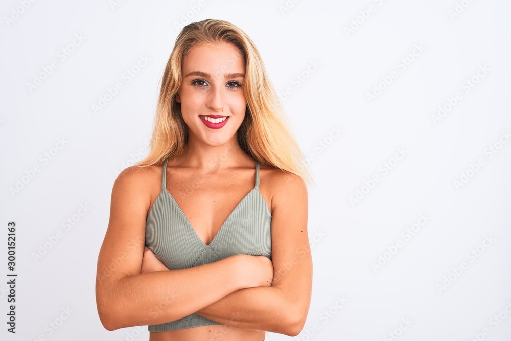 Young beautiful woman wearing casual green t-shirt standing over isolated white background happy face smiling with crossed arms looking at the camera. Positive person.