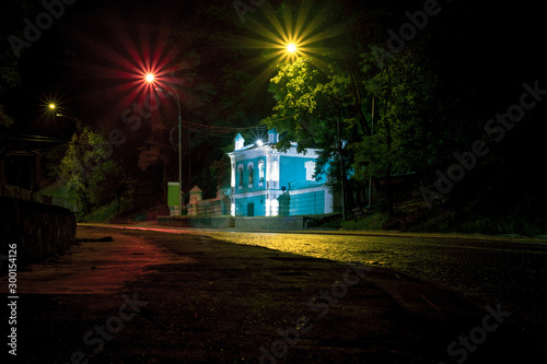 House in the old architectural style at night. Backlit blue house with two bright colorful lanterns