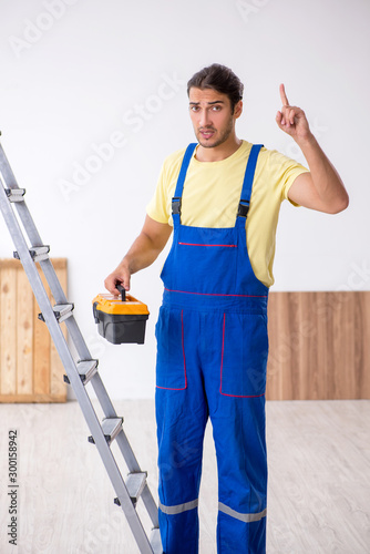Young male contractor working indoors