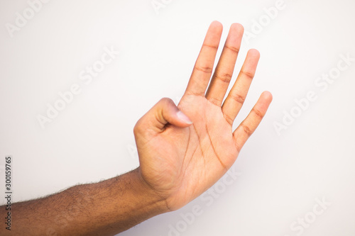 african american man arm with four fingers pointing up against white background