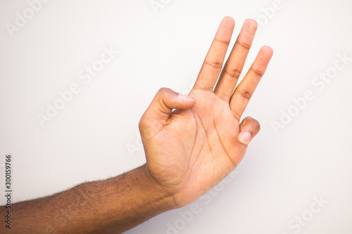 african american man arm with three fingers pointing up against white background