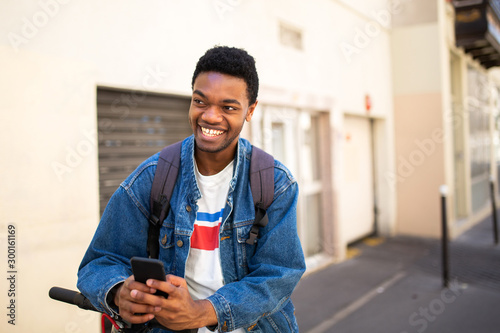 cool african american young man with mobile phone in city