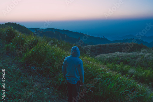 MAN STANDING OF BANGLADESHI TOP MOUNTAIN AND ENJOY THE NATURE