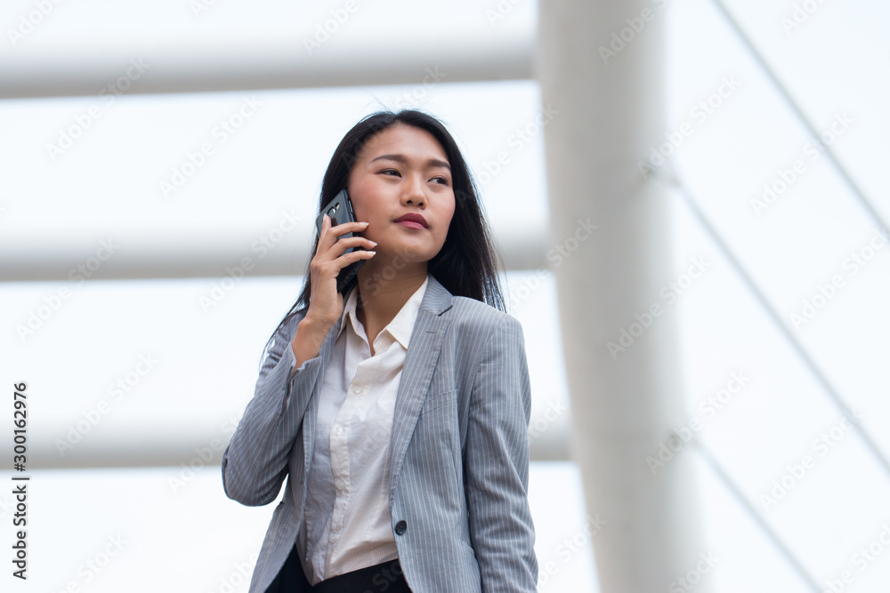 Asian Businesswoman Outside Office On Mobile Phone Asian Businesswoman Outside Office On Mobile Phone