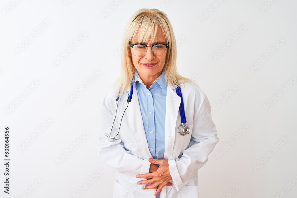 Middle age doctor woman wearing glasses and stethoscope over isolated white background with hand on stomach because indigestion, painful illness feeling unwell. Ache concept. Middle age doctor woman wearing glasses and stethoscope over isolated white background with hand on stomach because indigestion, painful illness feeling unwell. Ache concept.