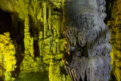 Cave rock formations are stalactites and stalagmites in colorful light. The miracle of the formation of stalagmites in the dark hall, Zeus Cave, Crete. Vacation and travel concept. horisontal