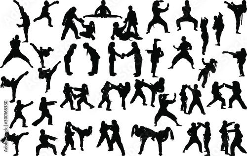 A large set of silhouettes of children of girls and boys practicing karate in different stances during the strike and blocks