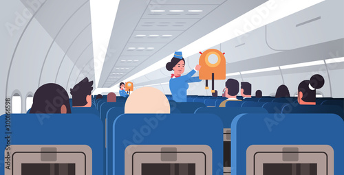 stewardess flight attendant explaining for passengers how to use jacket life vest in emergency situation safety demonstration concept modern airplane board interior horizontal flat vector illustration