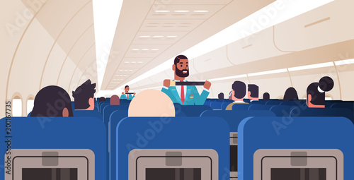 steward explaining passengers how to use seat belt fastening in emergency situation african american flight attendants in uniform safety demonstration concept airplane board interior horizontal vector