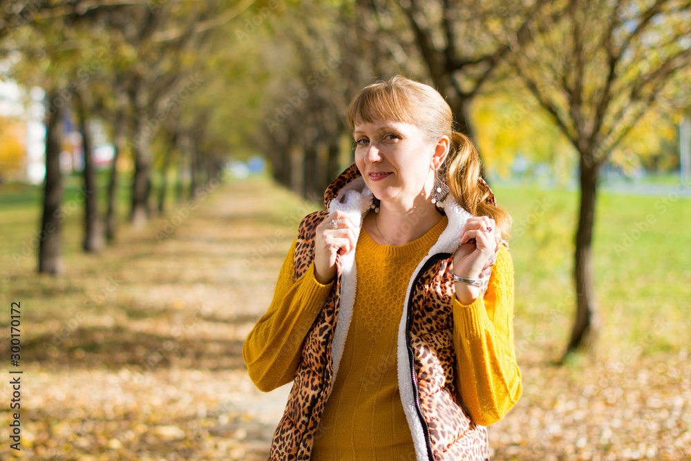 Obraz premium Portrait of a beautiful Russian woman 40 years old, in the autumn park.