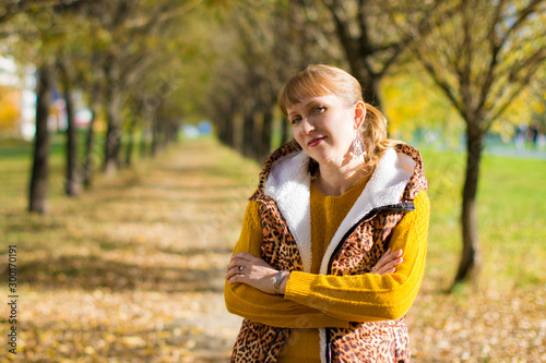 Portrait of a beautiful Russian woman 40 years old, in the autumn park.
