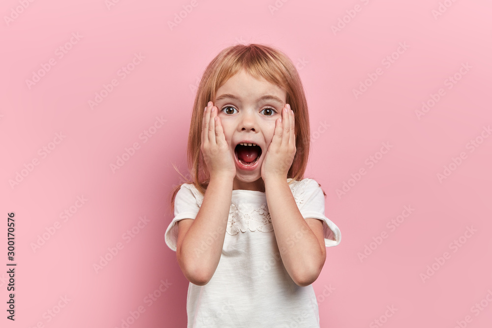 Close up photo little beautiful emotioal excited girl touching her cheeks, close up portrait, isolated pink background, studio shot, emotion, facial expression, reaction - obrazy, fototapety, plakaty 