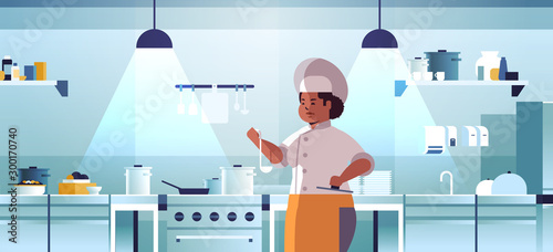 female professional chef cook preparing and tasting dishes african american woman in uniform near stove cooking food concept modern restaurant kitchen interior flat portrait horizontal vector