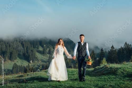 Groom with a bride or couple on a background of a beautiful mountain landscape. Wedding in the highlands.