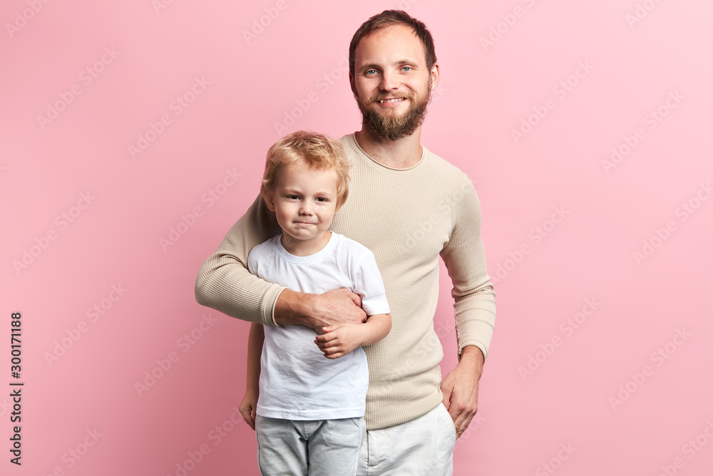 Happy daddy hugging his child, isolated pink background, studio shot, relationship. close up portrait, studio shot. Happy daddy hugging his child, isolated pink background, studio shot, relationship. close up portrait, studio shot.