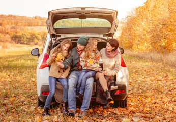 Family sitting in car trunk
