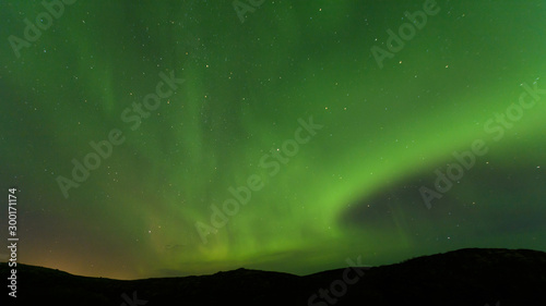 Aurora borealis over the hills. At night in the sky in the north.