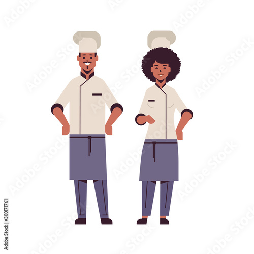 cooks couple professional chefs standing together african american man woman restaurant kitchen workers in uniform cooking food concept flat full length vector illustration