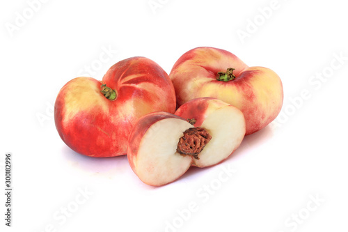 Two flat fig peaches with a half isolated on white