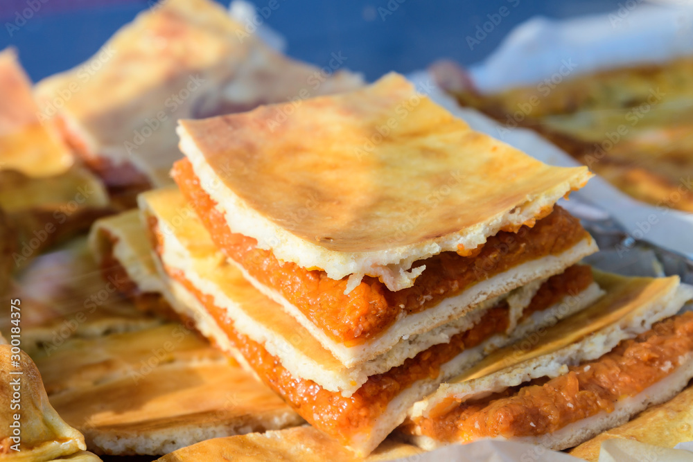 Freshly cooked traditional pumpkin pie in display for sale at a weekend street food market in Bucharest, Romania Freshly cooked traditional pumpkin pie in display for sale at a weekend street food market in Bucharest, Romania