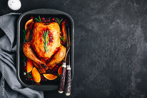Thanksgiving baked chicken or turkey with spices, oranges and cranberries photo