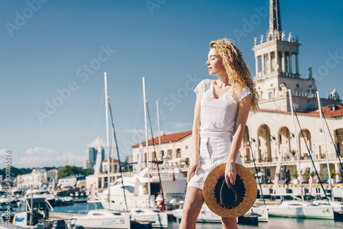 Foto curly blonde smiles cheerfully against the backdrop of the seaport