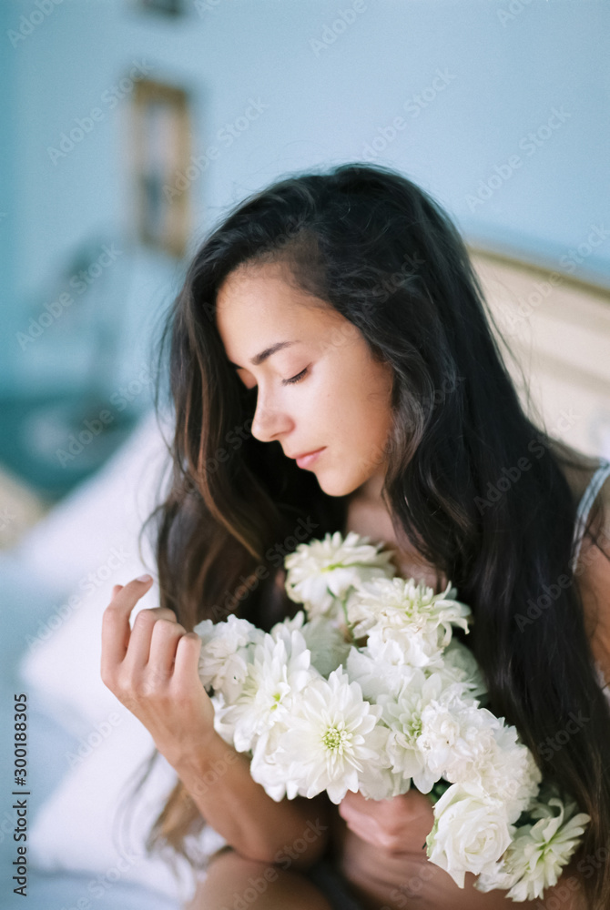 Morning portrait of young brunette woman with white flowers bouquet closeup Morning portrait of young brunette woman with white flowers bouquet closeup