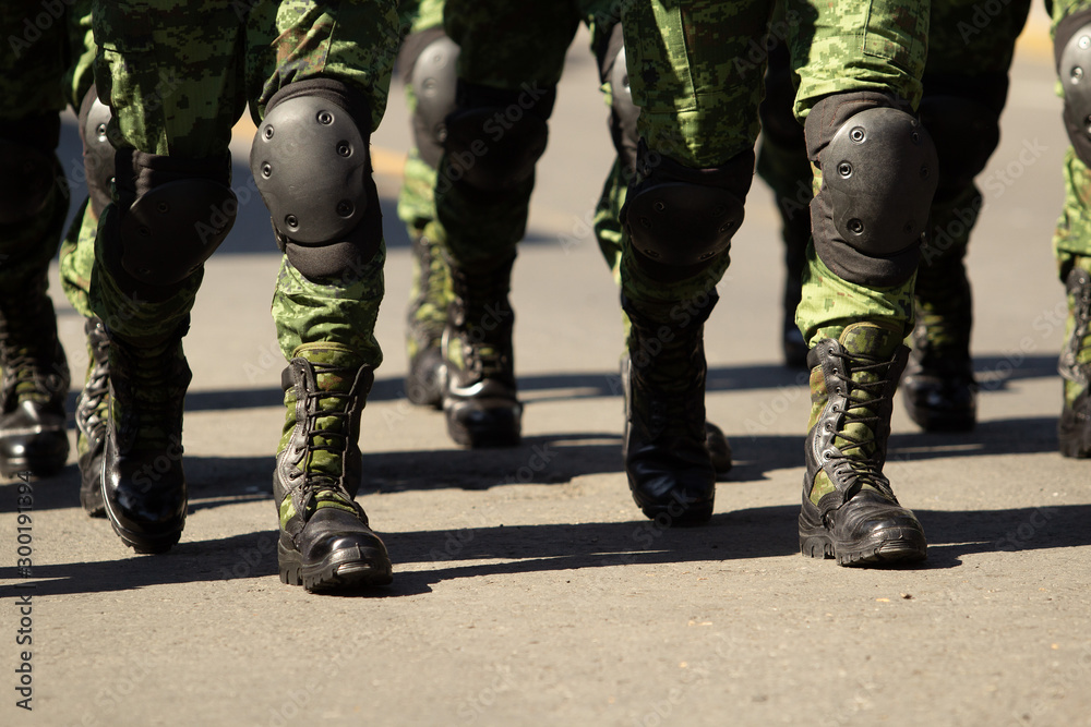close up of a group of military boots male soldiers at a parade, green camel military pants